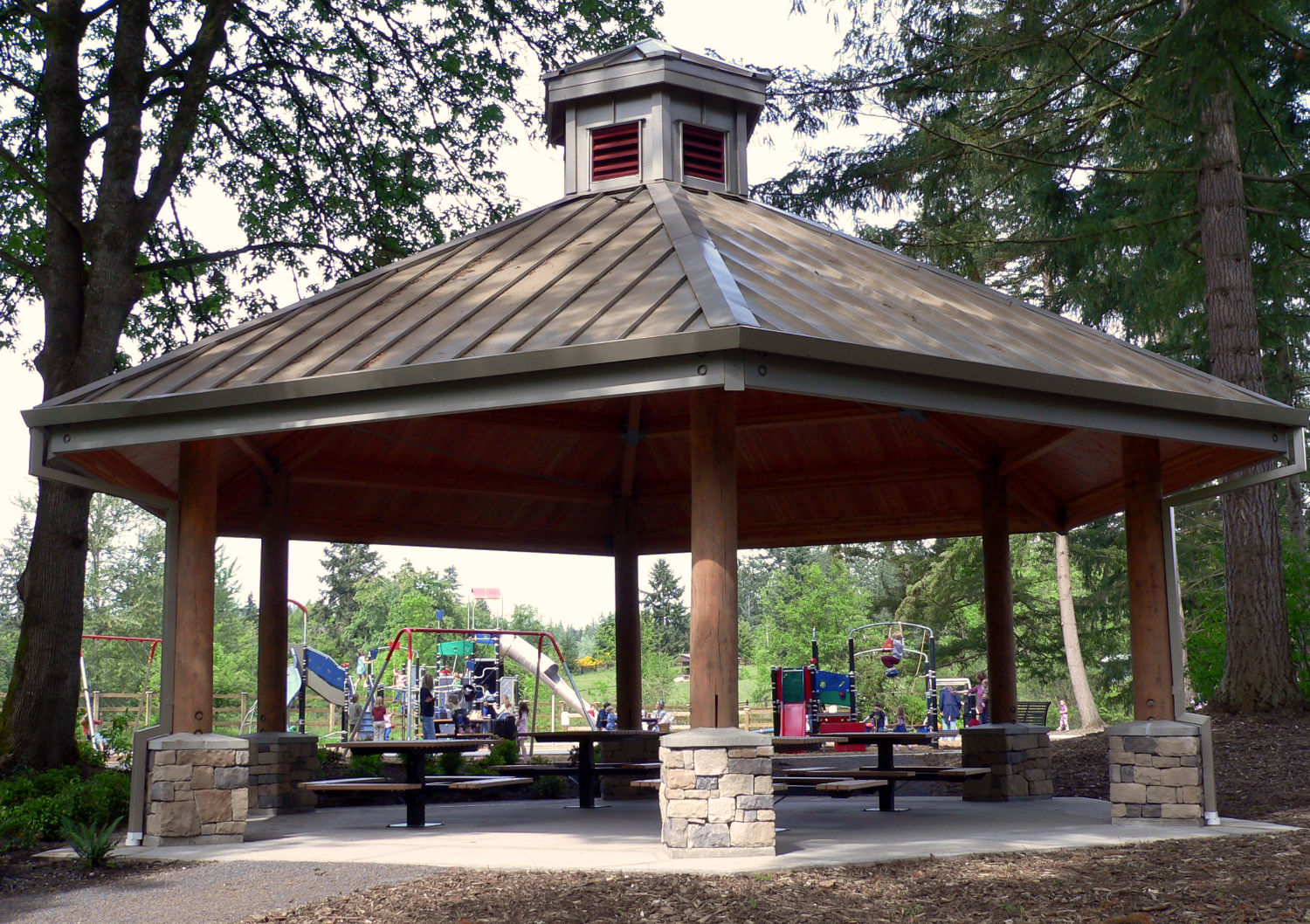 hexagonal picnic shelter at Ebright Creek, supported by six stone and wood columns