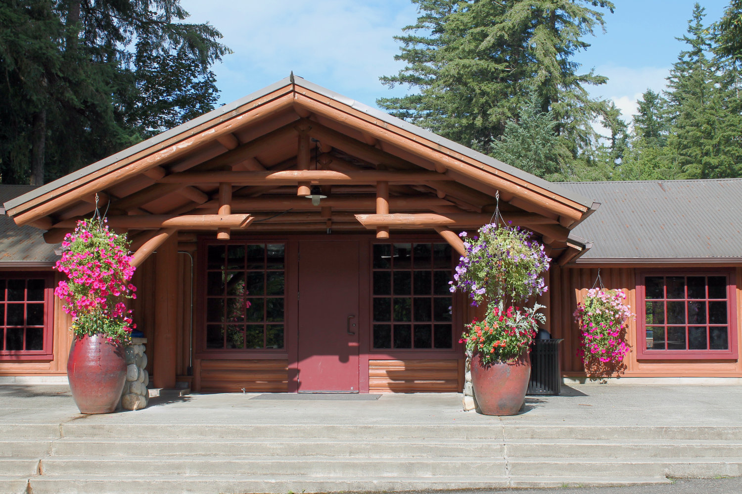 Front entrance to Beaver Lake Lodge with a giant flower-filled pot on each side of entrance. 